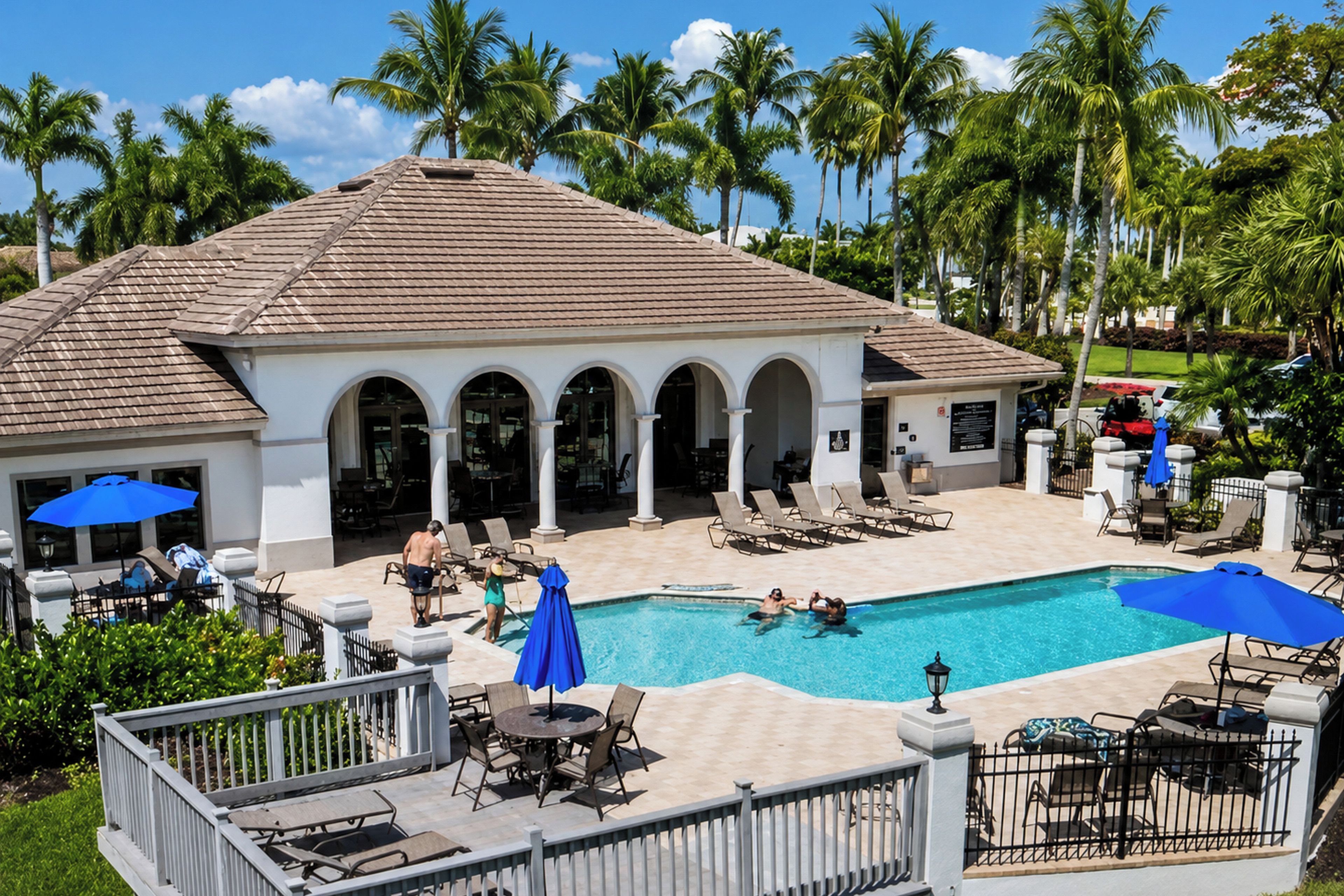 Ein Resort mit Swimmingpool, Liegestühlen und Palmen.