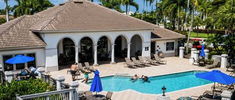 Un resort con piscina, sillas de descanso y palmeras.