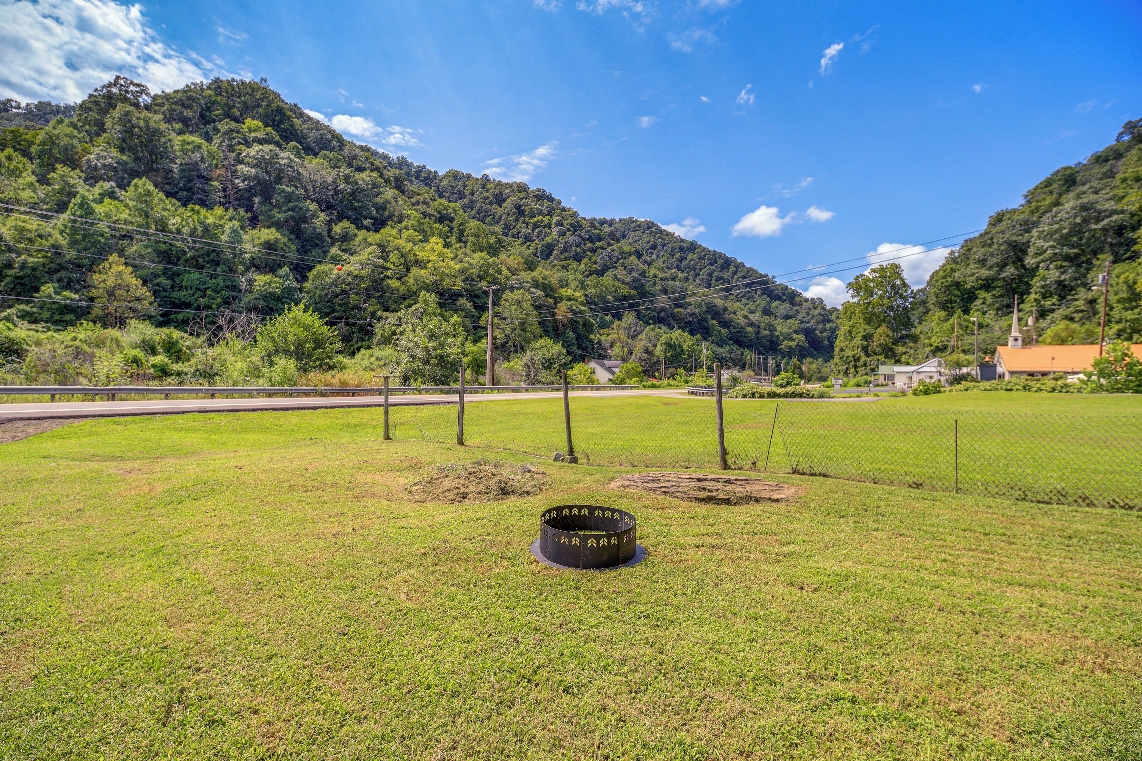 A grassy field with a metal structure, a road, and a mountain in the background.