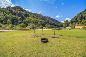 A grassy field with a metal structure, a road, and a mountain in the background.