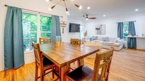 Un espacio de estar moderno con comedor, sofá y ventilador de techo.
