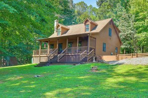 A two-story wooden cabin with a porch, a chimney, and a fenced yard. - Fishing Dock & Sauna! Farmville Gem w/ Views (Farmville)