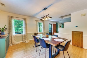 A dining area with a wooden table, black chairs, and a hanging light fixture. - Fishing Dock & Sauna! Farmville Gem w/ Views (Farmville)