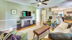 Una sala de estar con chimenea, zona de estar y televisor.