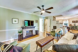 A living room with a fireplace, seating area, and a television.