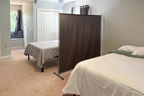 A bedroom with two beds, a window with curtains, and a door. - Fishing Dock & Sauna! Farmville Gem w/ Views (Farmville)