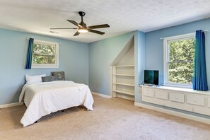 A bedroom with a bed, a ceiling fan, a window with curtains, and a built-in TV shelf. - Fishing Dock & Sauna! Farmville Gem w/ Views (Farmville)