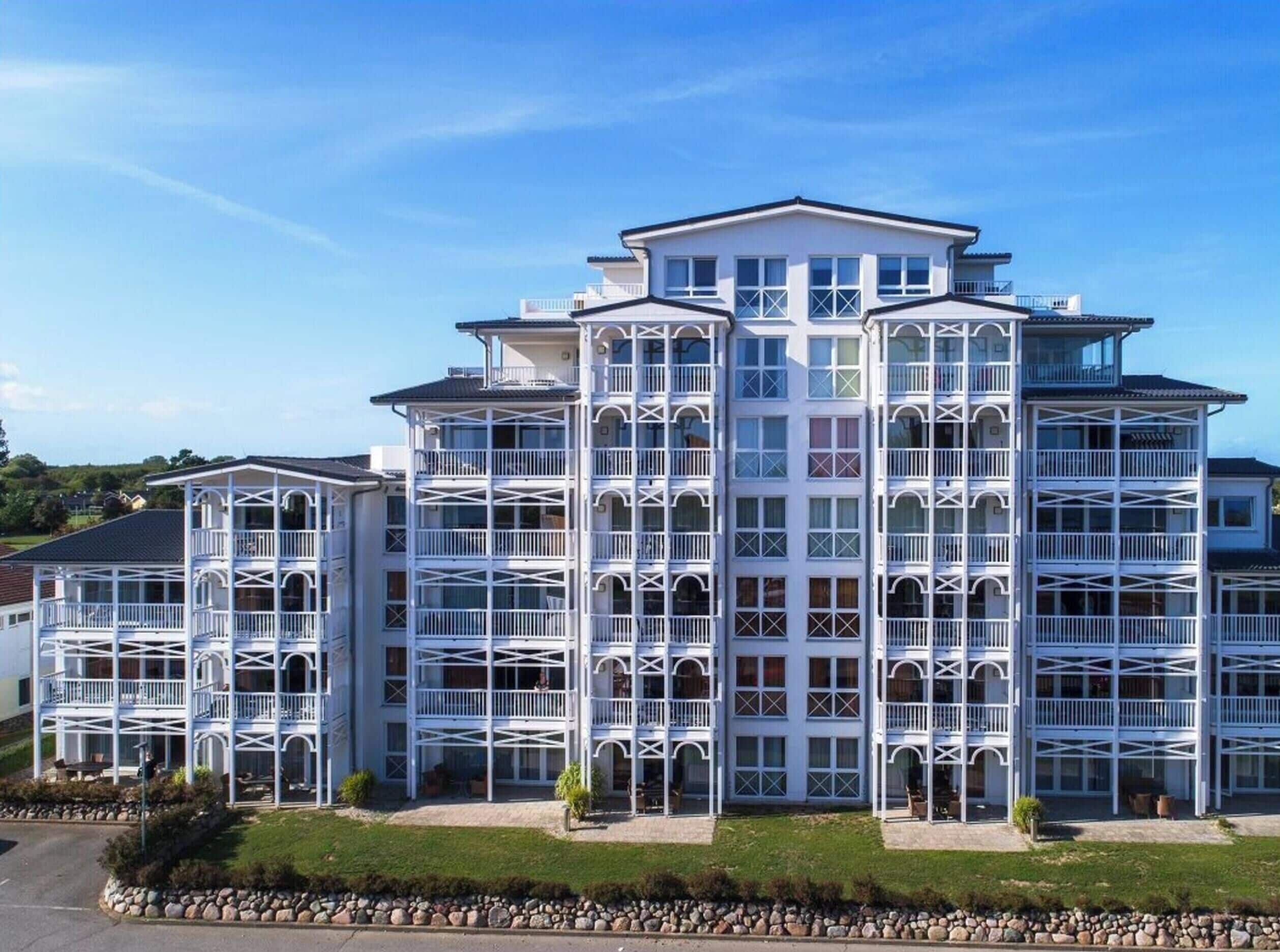 A multi-story hotel with a symmetrical facade, balconies, and a central entrance.