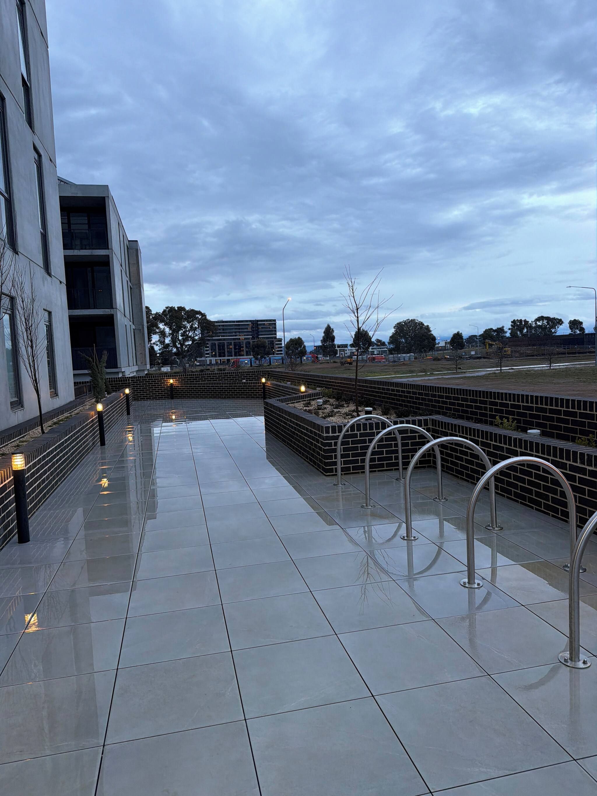 A modern building with a tiled walkway and metal railings.