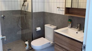 A modern bathroom with a glass-enclosed shower, a toilet, and a vanity with a mirror. - G6 Gungahlin brand new (Gungahlin)