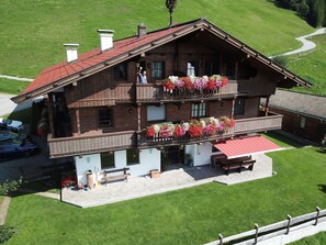 A wooden chalet with a balcony, a red awning, and flower boxes. - Hohe salve by Interhome (Hopfgarten im Brixental)