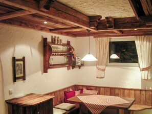 Un racó acollidor amb una banca de fusta, una taula amb estovell i una estant amb recipient de vidre.