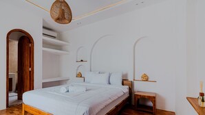 A bedroom with a wooden bed, white bedding, a small bedside table, and a hanging light fixture. - Costa Luna, Modern Mediterranean Villa Near Lancing Beach (Nusa Tenggara Bar.)