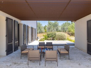 An outdoor patio with wicker furniture and a view of a garden. - San Giuseppe by Interhome (Cecina)
