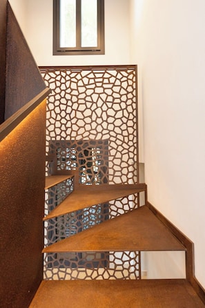 A spiral staircase with a geometric patterned wall behind it. - San Giuseppe by Interhome (Cecina)