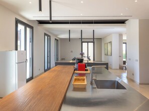 A modern kitchen with a wooden countertop, a built-in sink, and a large window. - San Giuseppe by Interhome (Cecina)