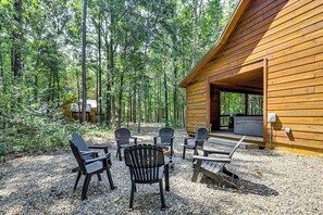 Eine Holzhütte mit Kiesterrasse, umgeben von einem Wald.