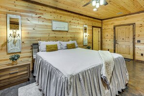 Een houten interieur met een bed, een spiegel en een ingelijste citaat aan de muur.