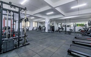 Ein Fitnessstudio mit verschiedenen Trainingsgeräten, darunter Laufbändern und Kraftgeräten.