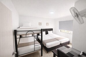 A room with bunk beds, a desk, a chair, a fan, and a window with blinds. - Casa Hotel Sweet Home Apt 203 Grupos (Medellín)