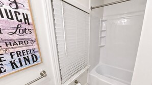 Une salle de bain avec une douche, des toilettes et un porte-serviettes.