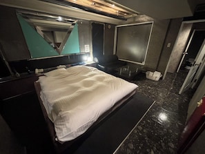 A hotel room with a bed, a large mirror, a television, and a bathroom. - HOTEL COCO (Chuo Ward, Sapporo City)