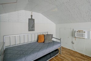A bedroom with a bunk bed, a wall-mounted air conditioning unit, and a chalkboard with text. - Family Apt 7 Mi to Gateway Arch, Museums & More! (St. Louis)