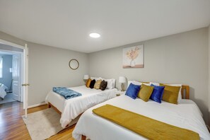 A hotel room with two beds, a door leading to a bathroom, and a painting on the wall. - Charming Family Home 11 Mi to Dtwn Richmond! (Chesterfield)