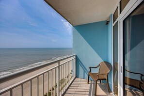 A balcony with a view of the ocean, a chair, and a glass door. - 15th-Floor Balcony! Myrtle Beach Oceanfront Oasis (Myrtle Beach)