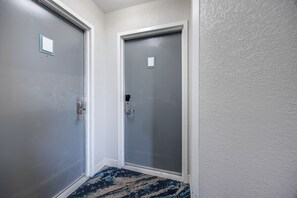 A hallway with two doors, one with a peephole and a handle, and the other with a doorbell. - 15th-Floor Balcony! Myrtle Beach Oceanfront Oasis (Myrtle Beach)