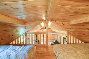 A wooden attic bedroom with a sloped ceiling, a bed, a desk, and a window. - Hiking/Biking Trails On-Site! Rustic Oxford Cabin (Oxford)