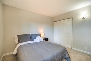 A bedroom with a bed, a nightstand, a lamp, and a door. - Mountain-View Basecamp in Central Colorado Springs (Colorado Springs)