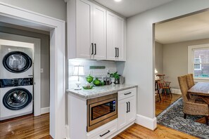 A modern kitchen with built-in appliances, white cabinetry, and a dining area with a view. - Downtown Salem Home: Walk to Main Street! (Salem)