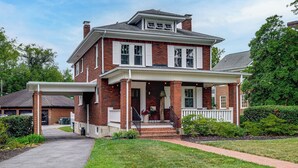 A two-story brick house with a front porch, a garage, and a well-maintained lawn. - Downtown Salem Home: Walk to Main Street! (Salem)