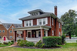 A two-story brick house with a front porch, a chimney, and a white picket fence. - Downtown Salem Home: Walk to Main Street! (Salem)
