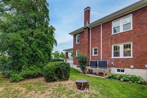 A two-story brick house with a large lawn, a chimney, and an air conditioning unit. - Downtown Salem Home: Walk to Main Street! (Salem)