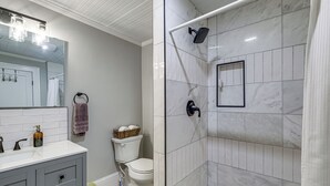 A bathroom with a shower, toilet, and vanity. - Downtown Salem Home: Walk to Main Street! (Salem)