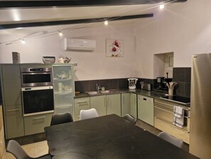 A modern kitchen with a built-in oven, a coffee maker, and a refrigerator. - Grande maison avec piscine et vue sur le Pilat (Maclas)