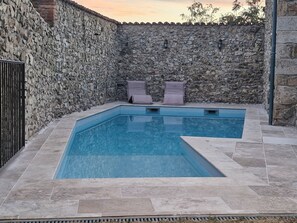 A swimming pool with stone walls and two lounge chairs. - Grande maison avec piscine et vue sur le Pilat (Maclas)