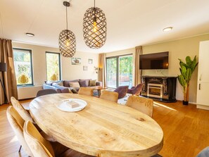 Ein modernes Wohnzimmer mit einem Holzesstisch, Sofas und einem Kamin.