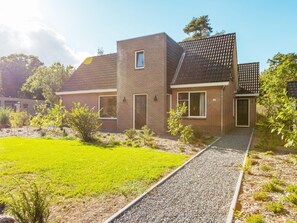 Ein modernes, zweistöckiges Haus mit einem Schotterweg und einem gepflegten Rasen.