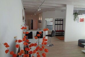 A modern interior with a kitchen area, a dining space with bar stools, and a seating area with a bench. - Holiday apartment with 2 bedrooms (Steinweiler)