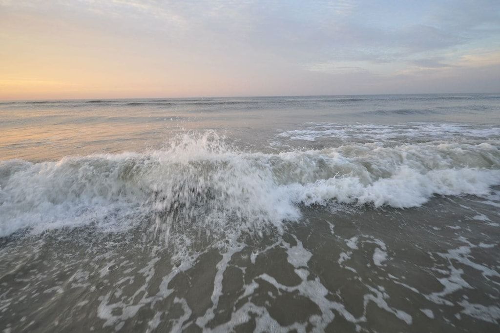 Een strand met golven die de kust naderen.