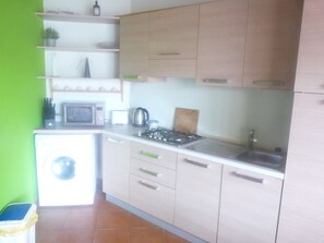 A compact kitchen with a microwave, toaster, kettle, and gas stove. - Studio apartment in beachfront complex & 2 minutes walk to town (Santa Maria)