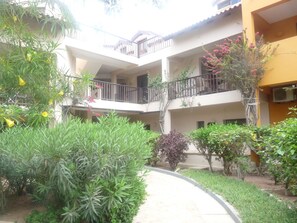 A multi-level building with balconies, surrounded by greenery and a pathway. - Studio apartment in beachfront complex & 2 minutes walk to town (Santa Maria)