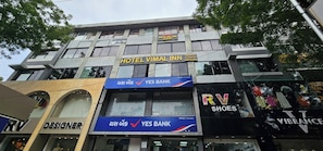 A multi-story building with a sign for Hotel Vimal Inn on the second floor.