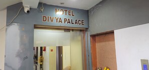 A hotel entrance with a sign reading 'HOTEL DIVYA PALACE'.