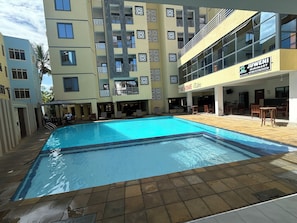 A swimming pool with a tiled deck, a restaurant named 'The Home Plate,' and a building with balconies and patterned windows. -
Cozy 1 bedroom with AC and hot shower. 3 mins to the beach. Pool, gym/game room (Mombasa)