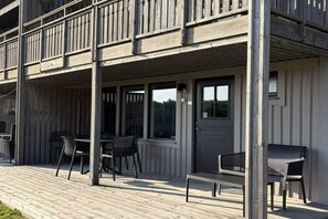 A wooden deck with outdoor seating and a covered area. - 4 star holiday home in UDDEVALLA (UDDEVALLA)