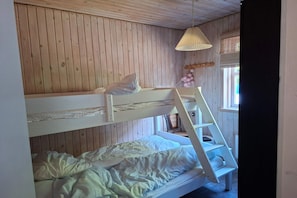 A bunk bed room with a ladder, wooden walls, and a hanging light fixture. - 4 star holiday home in Sæby (Sæby)